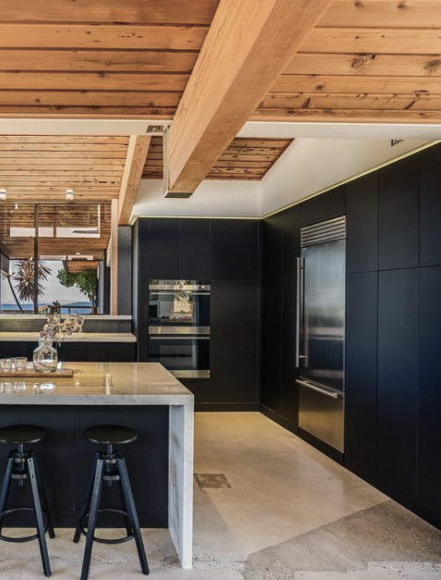 Modern kitchen with marble island, dark cabinets and wood ceiling